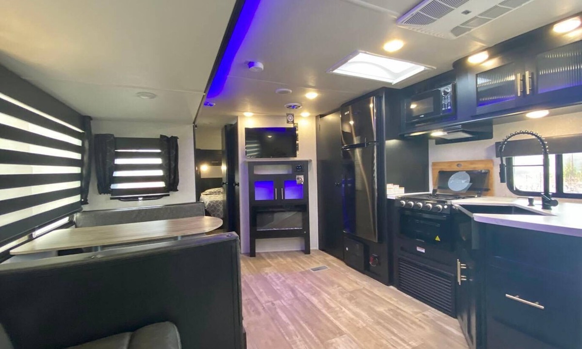 Talent House | Cherokee RV features a queen-sized bed, dining area, and full kitchen.