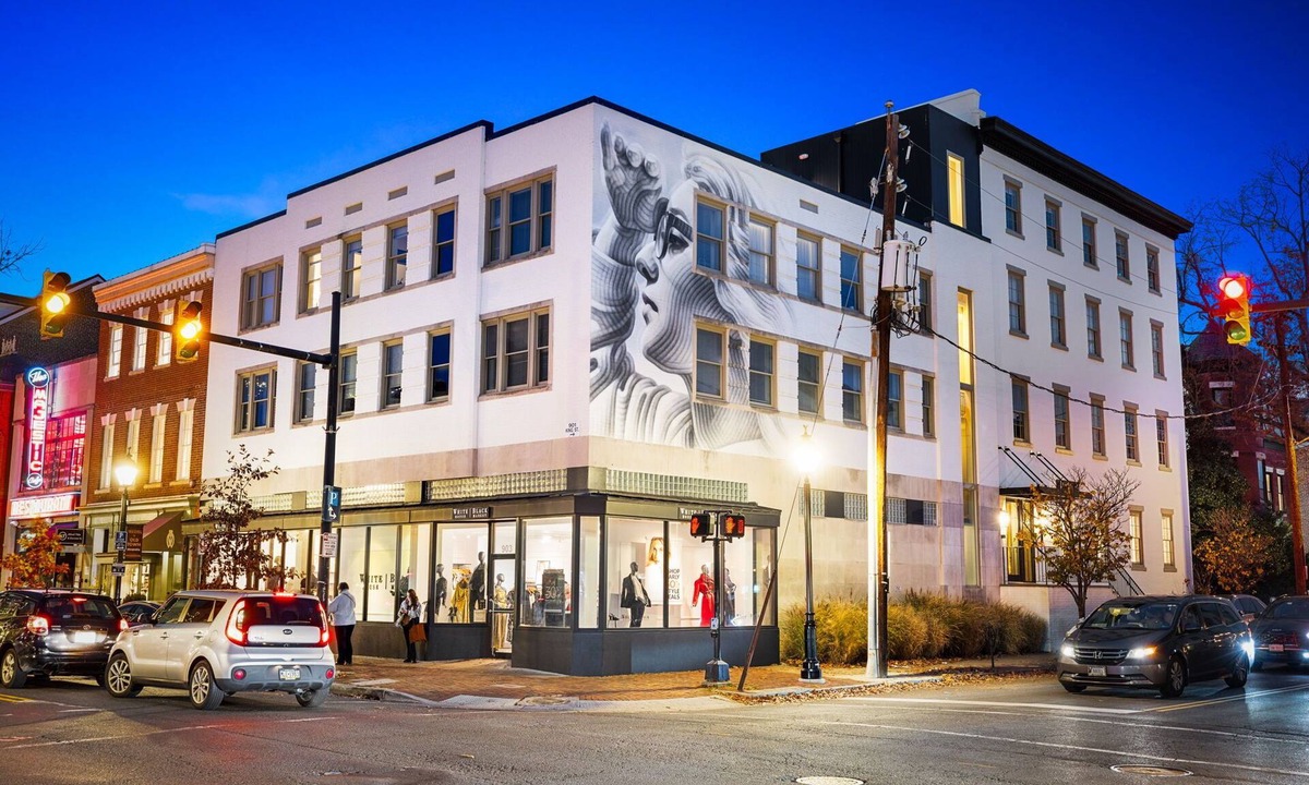 Old Town Alexandria Apartment | Design-forward flat in Old Town's most iconic building. Exposed brick, bold red ceiling pipes, corner bedroom bathed in natural light. Modern kitchen, quiet side street. Steps from 100+ restaurants & waterfront. A LovableBNB Collection listing.