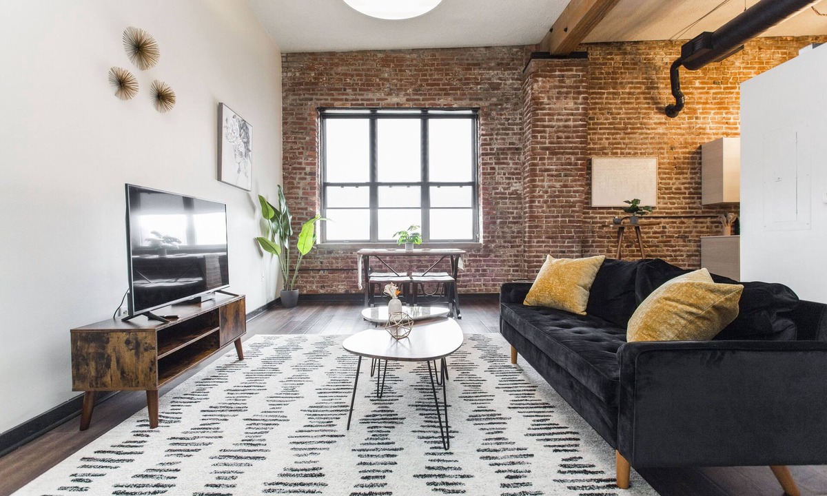 Kansas City Apartment | Exposed brick, wood beams, & chic touches give this loft serious style. Enjoy skyline views from the rooftop, a full kitchen with coffee bar, king bed, on-site gym, & quick access to the free KC streetcar. Walk to shops/dining, and the City Market!