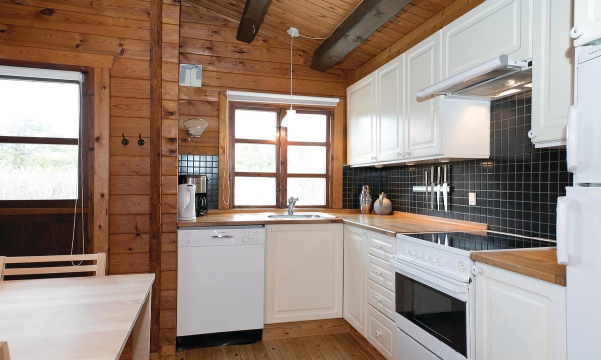 Pandrup House | On a natural plot near the water lies this renovated log house with beautiful terrace.