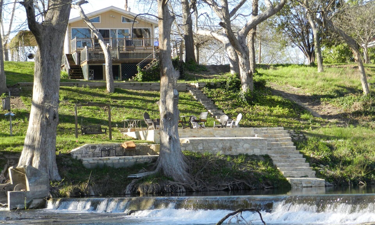 New Braunfels House | Scenic riverfront home on quiet stretch of Guadalupe - waterfall by front porch