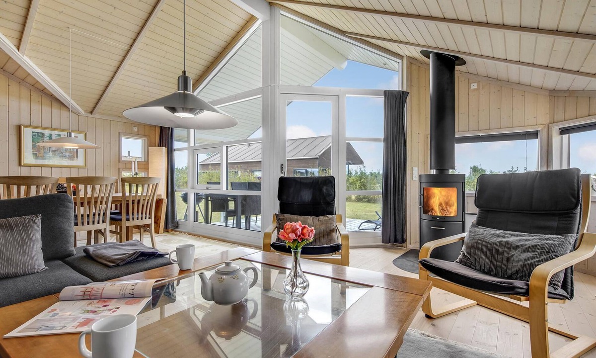 Havnsø House | The cottage has an inviting kitchen-living room with a fireplace and a partially covered terrace.