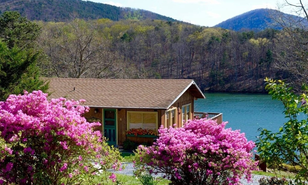 Huddleston Cabin | This cozy 2-bedroom, 1-bath retreat is wrapped in warm cedar with soaring cathedral ceilings, creating the perfect blend of rustic charm. Enjoy beautiful gardens and breathtaking views of the lake and mountain.