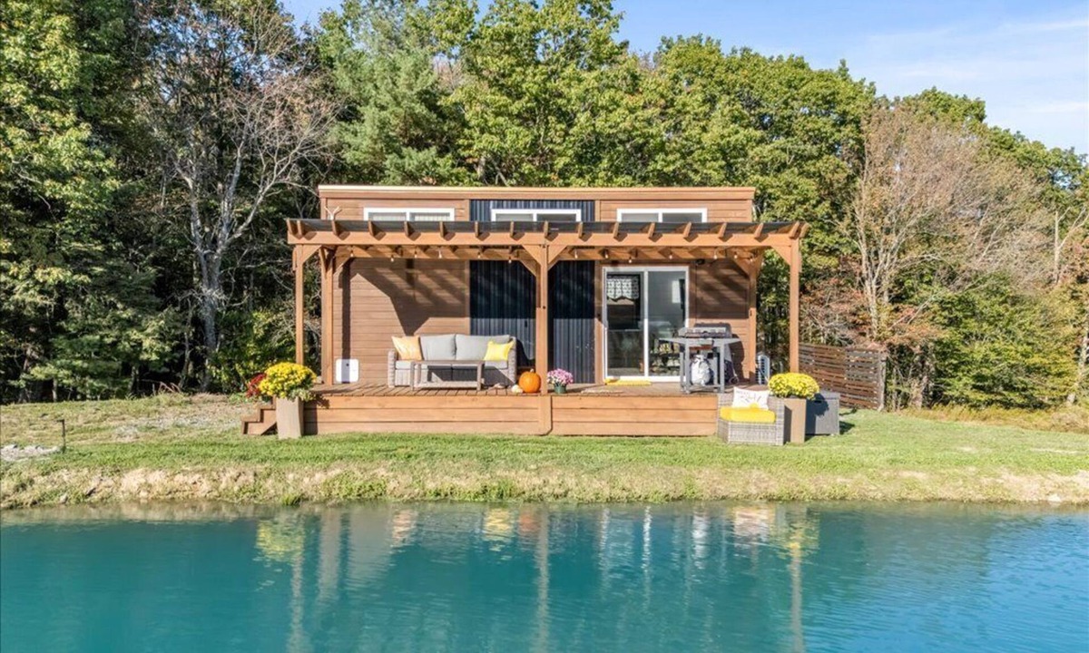 Brackney Cabin | Waterfront Tiny House Perched on the Pond Covered Deck at Water’s Edge