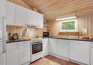 On a hilly natural plot surrounded by trees, lies this beautiful wooden vacation home.