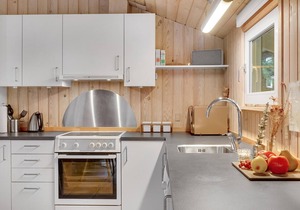 On a hilly natural plot surrounded by trees, lies this beautiful wooden vacation home.