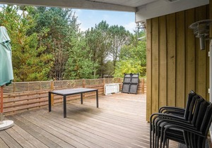 On a hilly natural plot surrounded by trees, lies this beautiful wooden vacation home.