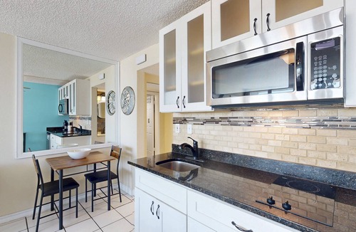 Treasure Island Condo | Beachfront Balcony ~ View of Treasure Island Beach ~ Heated Pool, Tiki Bar, BBQ Grills, Volleyball.