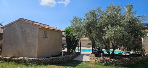 Aleria House | Bed and kitchen with pool