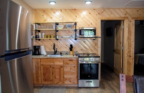 Carlisle Cabin | Cabin Bunkhouse with Hot Tub on Private Lake, Fire Pit & Swings in Vian, OK!