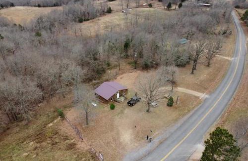 Marshall House | Cabin with a tree house on a buffalo farm .