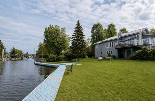 Lagoon City Cottage | Canalside summer cottage w/river views, fire table & outdoor cushioned seating