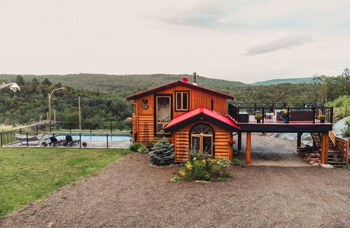 Mandeville Cabin | Charming log cabin nestled in the woods, with a spa and in-ground pool.