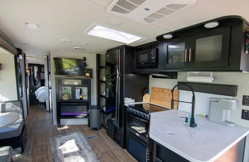 Talent House | Cherokee RV features a queen-sized bed, dining area, and full kitchen.