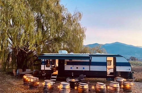 Talent House | Cherokee RV features a queen-sized bed, dining area, and full kitchen.