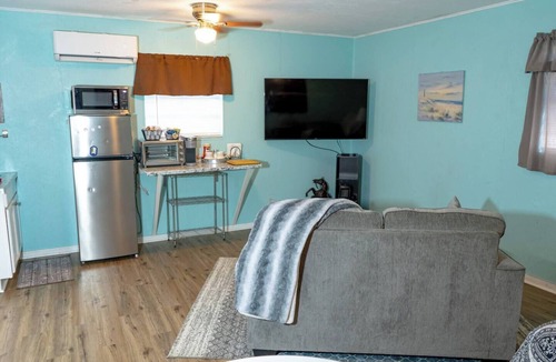 Saint Jo Cabin | Cozy downtown studio for 2 within walking distance to Red River Station. Features a king bed, kitchenette, smart TV, Wi-Fi, free parking, and a peaceful private patio.