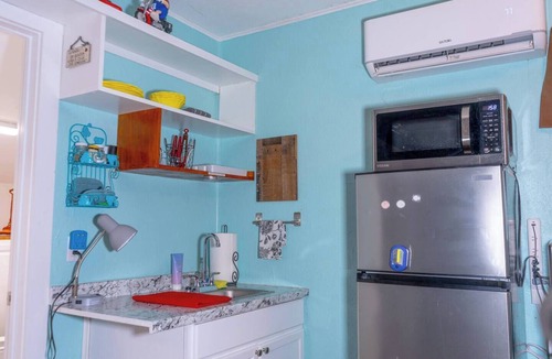 Saint Jo Cabin | Cozy downtown studio for 2 within walking distance to Red River Station. Features a king bed, kitchenette, smart TV, Wi-Fi, free parking, and a peaceful private patio.