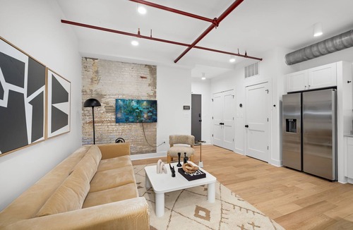 Old Town Alexandria Apartment | Design-forward flat in Old Town's most iconic building. Exposed brick, bold red ceiling pipes, corner bedroom bathed in natural light. Modern kitchen, quiet side street. Steps from 100+ restaurants & waterfront. A LovableBNB Collection listing.