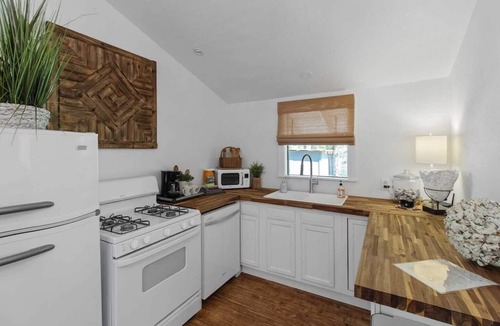 Shreveport Cabin | Emerald Cottage offers a laid-back stay surrounded by towering trees, with a spacious deck, kayaks and canoes to paddle through the cypress forest, and a firepit perfect for slow evenings outside.
