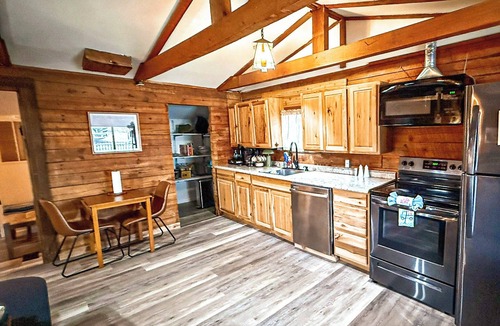 Lake Ozark House | Escape to Grandpa John’s Cabin in Four Seasons near Shady Gators & Camden on the Lake. This restored 2 bed, 2 bath log cabin features a king suite, bunk room, fireplace, coffee bar, deck, firepit, pet-friendly stay, and parking for cars & small boat.