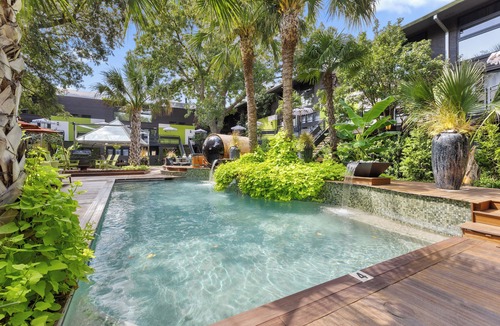 Old East Dallas Condo | Experience elevated comfort in this upscale 2-bedroom Dallas condo with pool views and exclusive access to an award-winning courtyard featuring a resort-style pool, hot tub, dry sauna, and lush lounge areas. Enjoy a 77″ smart TV, sleek leather sofa,