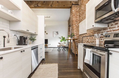 Kansas City Apartment | Exposed brick, wood beams, & chic touches give this loft serious style. Enjoy skyline views from the rooftop, a full kitchen with coffee bar, king bed, on-site gym, & quick access to the free KC streetcar. Walk to shops/dining, and the City Market!