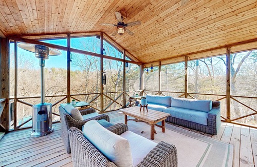 Powell House | Lakefront retreat with screened sunroom, wood stove, multiple decks, & AC