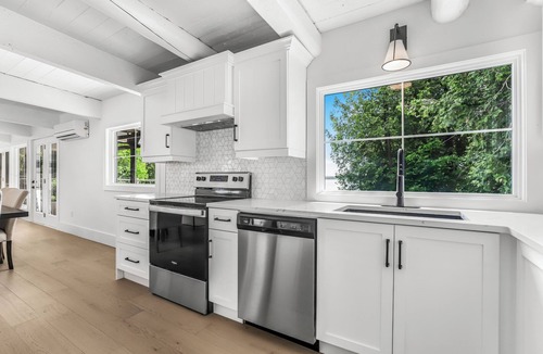 Stokes Bay House | Midnight Star is a bright, modern Stokes Bay waterfront cottage with 3 bedrooms, 2 bathrooms, a private dock, sauna, hot tub, stone fireplace, open-concept living, and epic sunsets—perfect for easy Bruce Peninsula lake days.