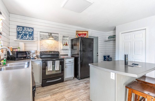 Woods Bay House | Mountain-view home with large deck, gas grill, firepit, lawn, and central AC