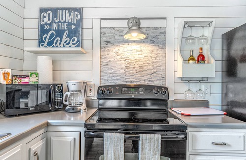 Woods Bay House | Mountain-view home with large deck, gas grill, firepit, lawn, and central AC