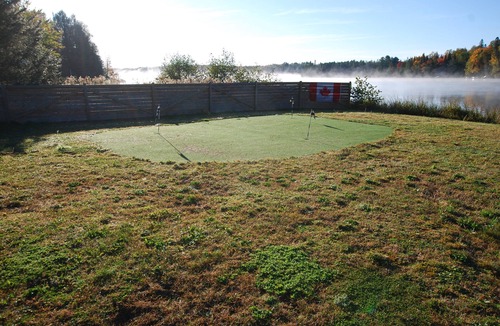 Rye Cottage | nCozy waterfront cottage, sandy beach front, sunken hot tub, with putting green.