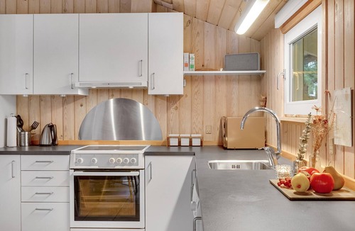 Vorupør House | On a hilly natural plot surrounded by trees, lies this beautiful wooden vacation home.