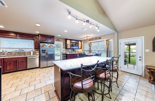 Pflugerville House | Ranch Home w Gorgeous Kitchen-Office-Big Screens-Covered Porch-Playscape & Lg Basketball Court