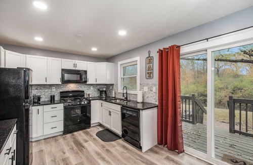 Grandview House | Remodeled 3BR w/queen beds on 1/2 acre backing to open space. Bonus basement living room + extra bath. Chef’s kitchen, W/D, patio + outdoor dining. Bright, private setting w/shade trees near Raymore/Belton. Fast WiFi.