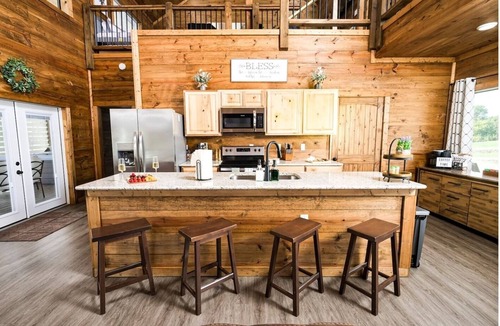 Golden Cabin | Rustic cabin on a quiet stretch of the Glover River. Three queen suites and a bunk loft sleep up to 13. Kayak from the backyard, soak in the hot tub, gather at the fire pit. Inside: game loft with ping pong, and Nintendo. FREE Gym at Sweat Shack.