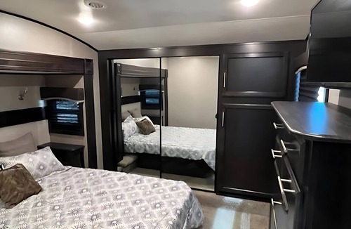 Kenora Resort | RV 5 Rustic Charm w/Queen Bed with Forest Background