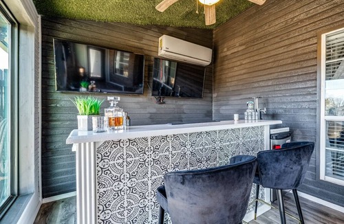 San Angelo House | Stylish corner home with cozy interiors, a private bar, and inviting charm