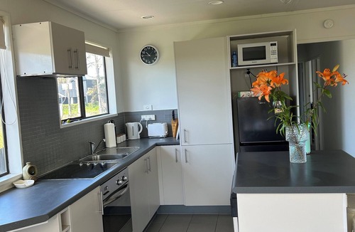 Papamoa Beach House | Sunny Papamoa beach bach- steps to the sand….