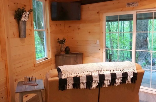 Darlington House | The Chalet is located in the woods of a gated property with a covered porch.