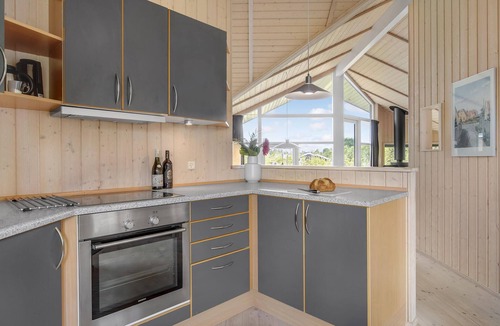 Havnsø House | The cottage has an inviting kitchen-living room with a fireplace and a partially covered terrace.
