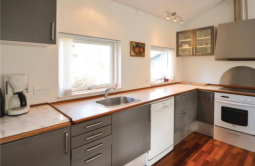 Lyngsbæk Strand House | The cottage is beautifully placed on a large fenced natural ground, where lawn has been laid.