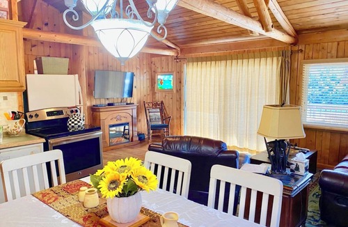 Huddleston Cabin | This cozy 2-bedroom, 1-bath retreat is wrapped in warm cedar with soaring cathedral ceilings, creating the perfect blend of rustic charm. Enjoy beautiful gardens and breathtaking views of the lake and mountain.