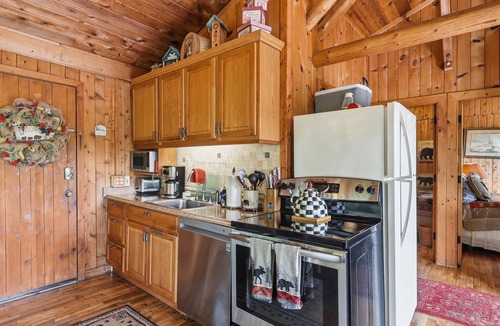 Huddleston Cabin | This cozy 2-bedroom, 1-bath retreat is wrapped in warm cedar with soaring cathedral ceilings, creating the perfect blend of rustic charm. Enjoy beautiful gardens and breathtaking views of the lake and mountain.