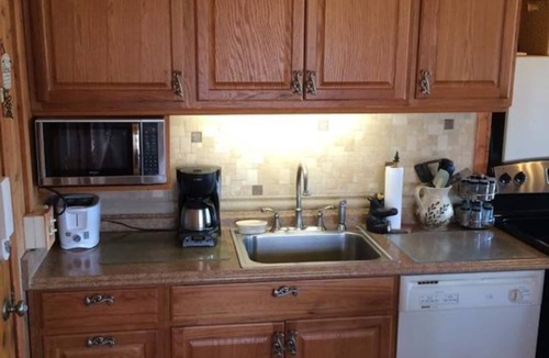 Huddleston Cabin | This cozy 2-bedroom, 1-bath retreat is wrapped in warm cedar with soaring cathedral ceilings, creating the perfect blend of rustic charm. Enjoy beautiful gardens and breathtaking views of the lake and mountain.