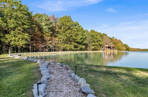 Brackney Cabin | Waterfront Tiny House Perched on the Pond Covered Deck at Water’s Edge