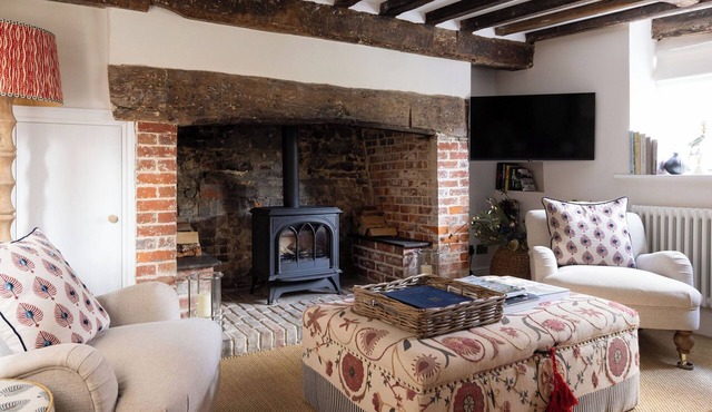 A charming Grade II listed holiday home in Petworth, recently remodelled with original beams, 3 bedrooms, 2 bathrooms a modern kitchen, cosy living space, and a large garden with pergola seating.