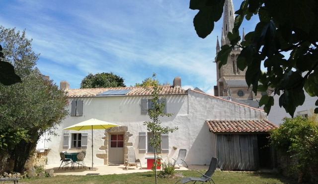 a charming little house deep in a fenced garden with stone walls