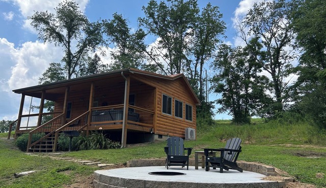 A cozy new cabin in rural setting with a hot tub on porch. Beautiful rural view.