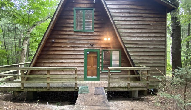 A-frame cabin nestled in forest, stunning lake view, perfect serenity.