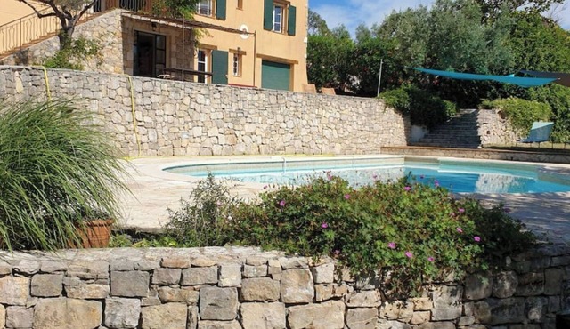 A green setting between sea and mountains